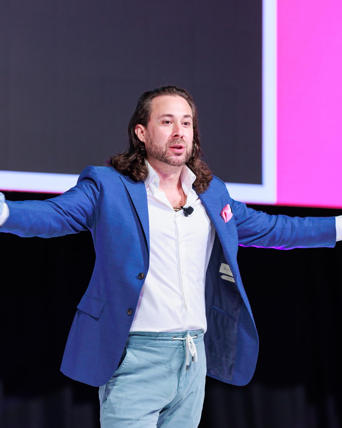 Eric Silverberg on stage, arms wide, mid keynote